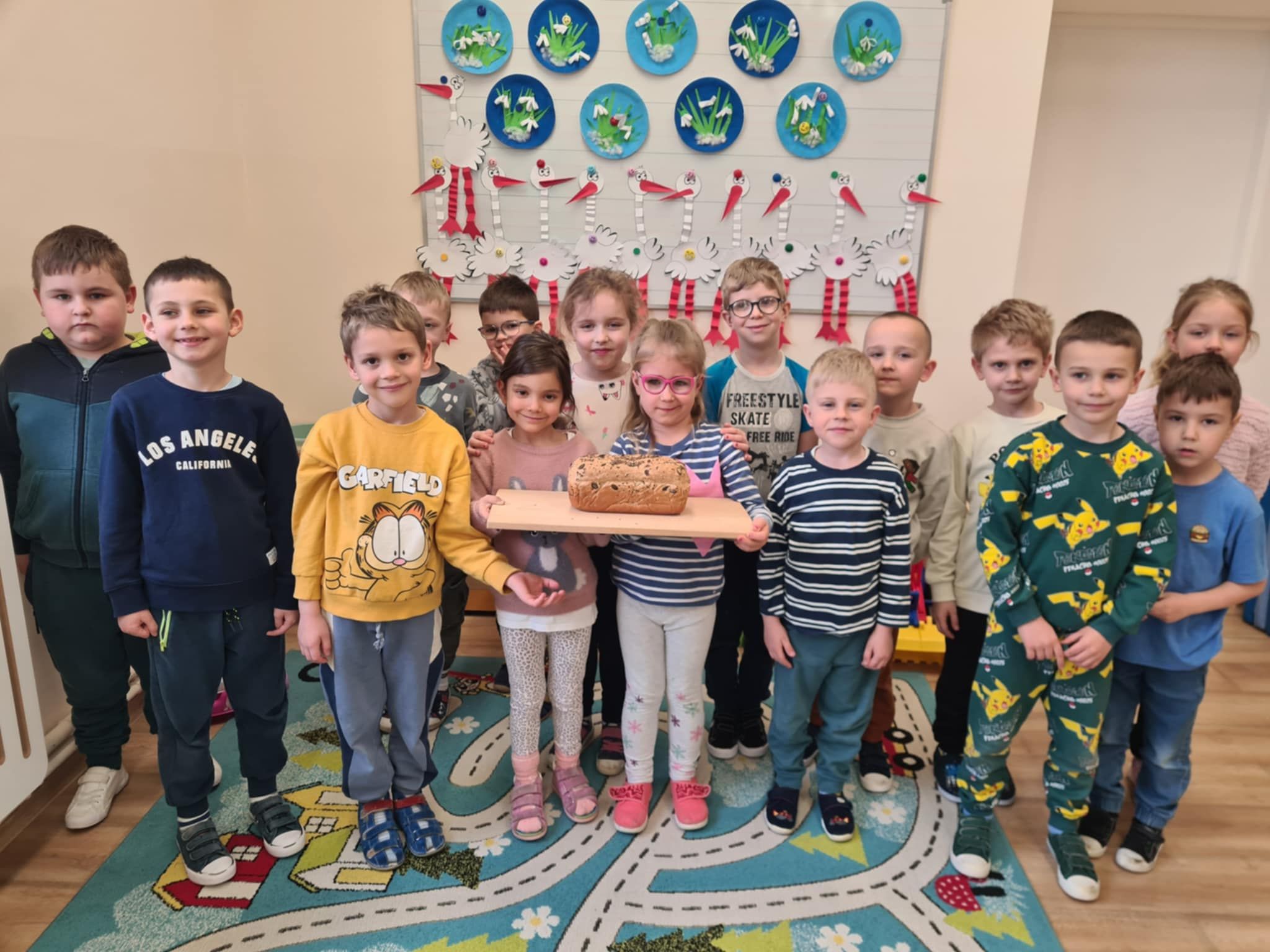 Dzieci stojący w grupie trzymający w foremce chleb