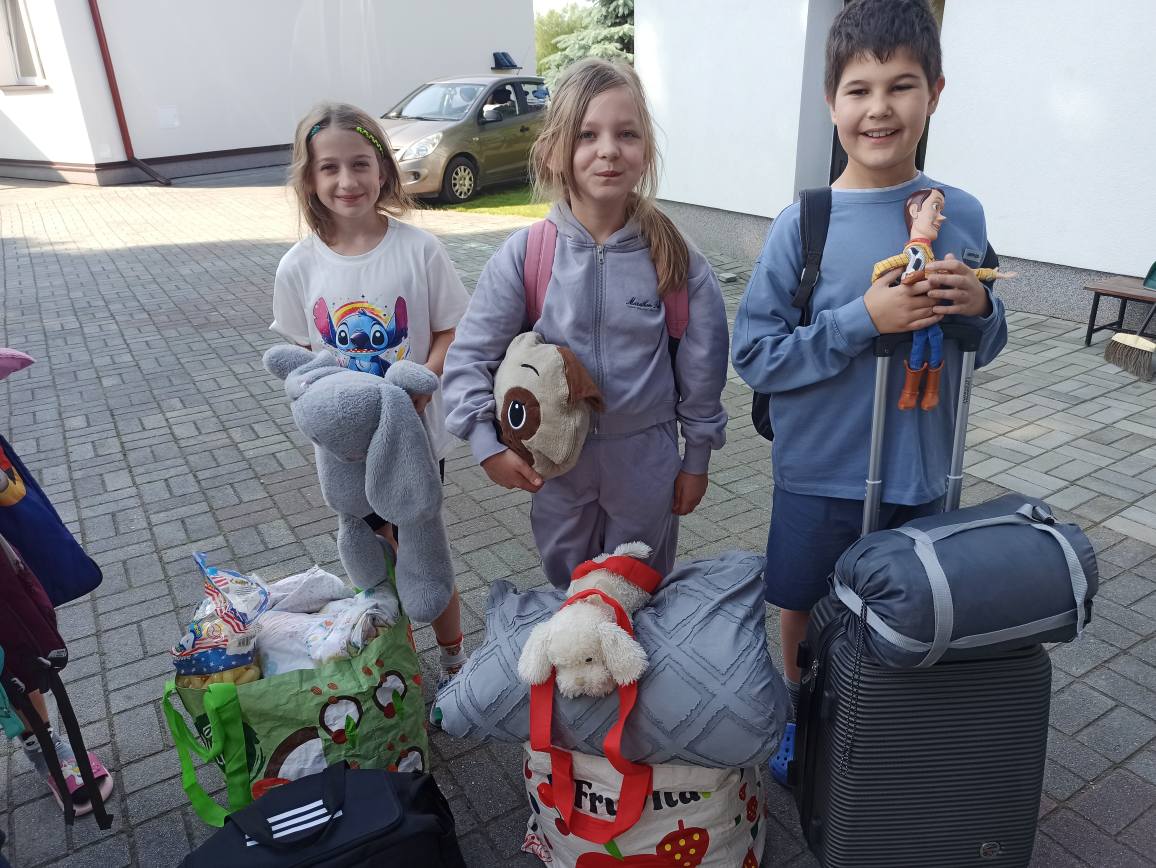 Uczniowie stojący z walizkami szykujący się do nocowania w szkole