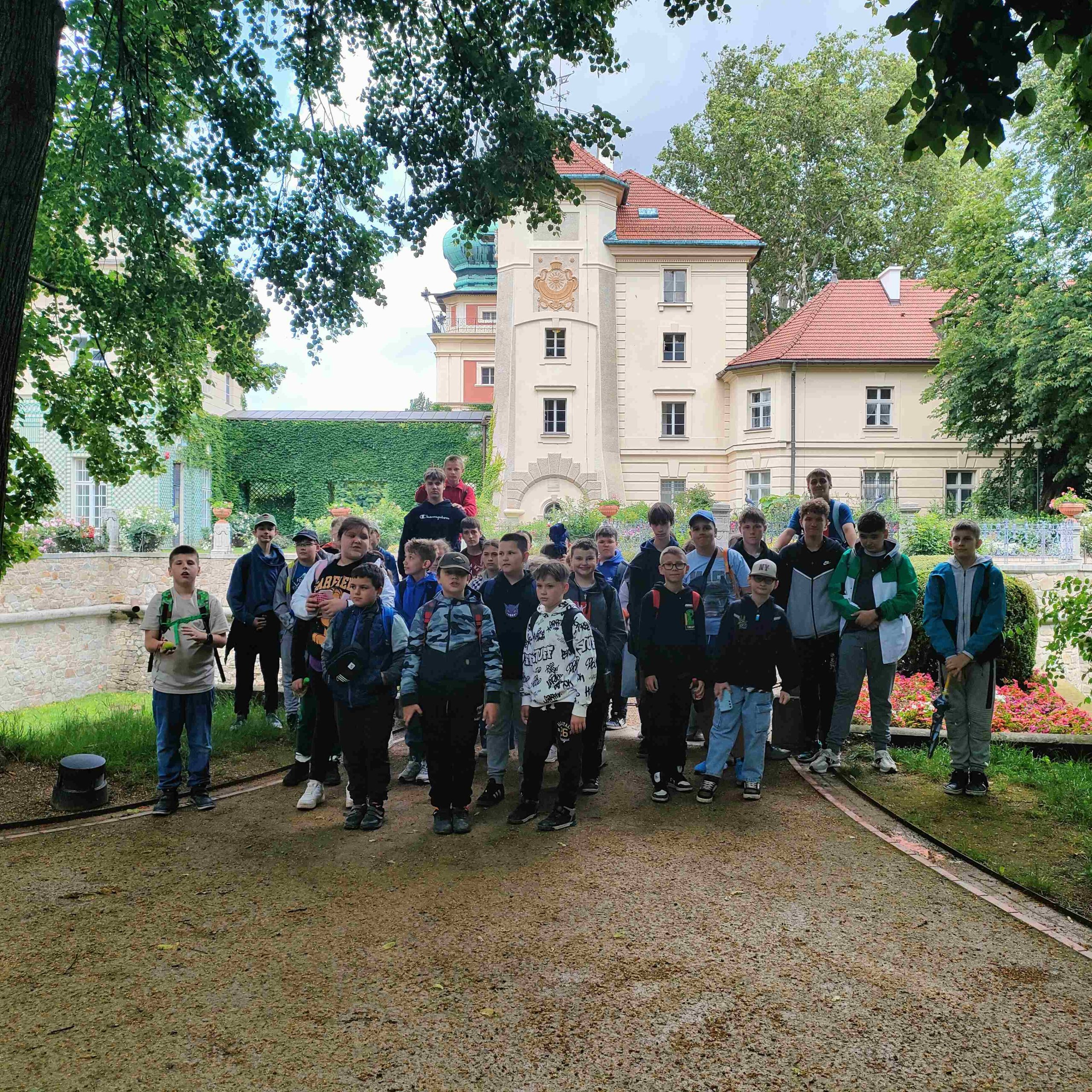 Uczniowie stojący na tle zamku w Łańcucie