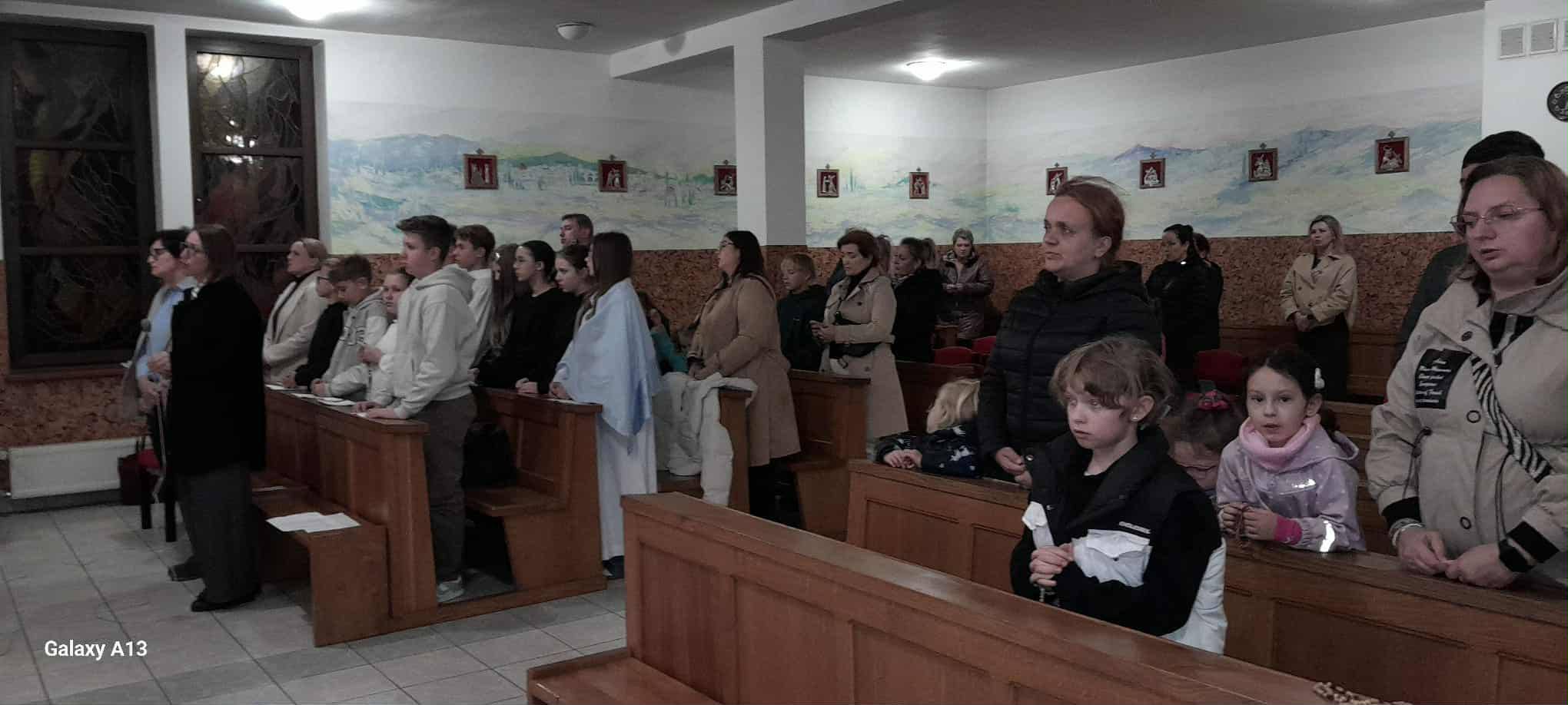Rodzice wraz z dziećmi uczestniczący na modlitwie różańcowej