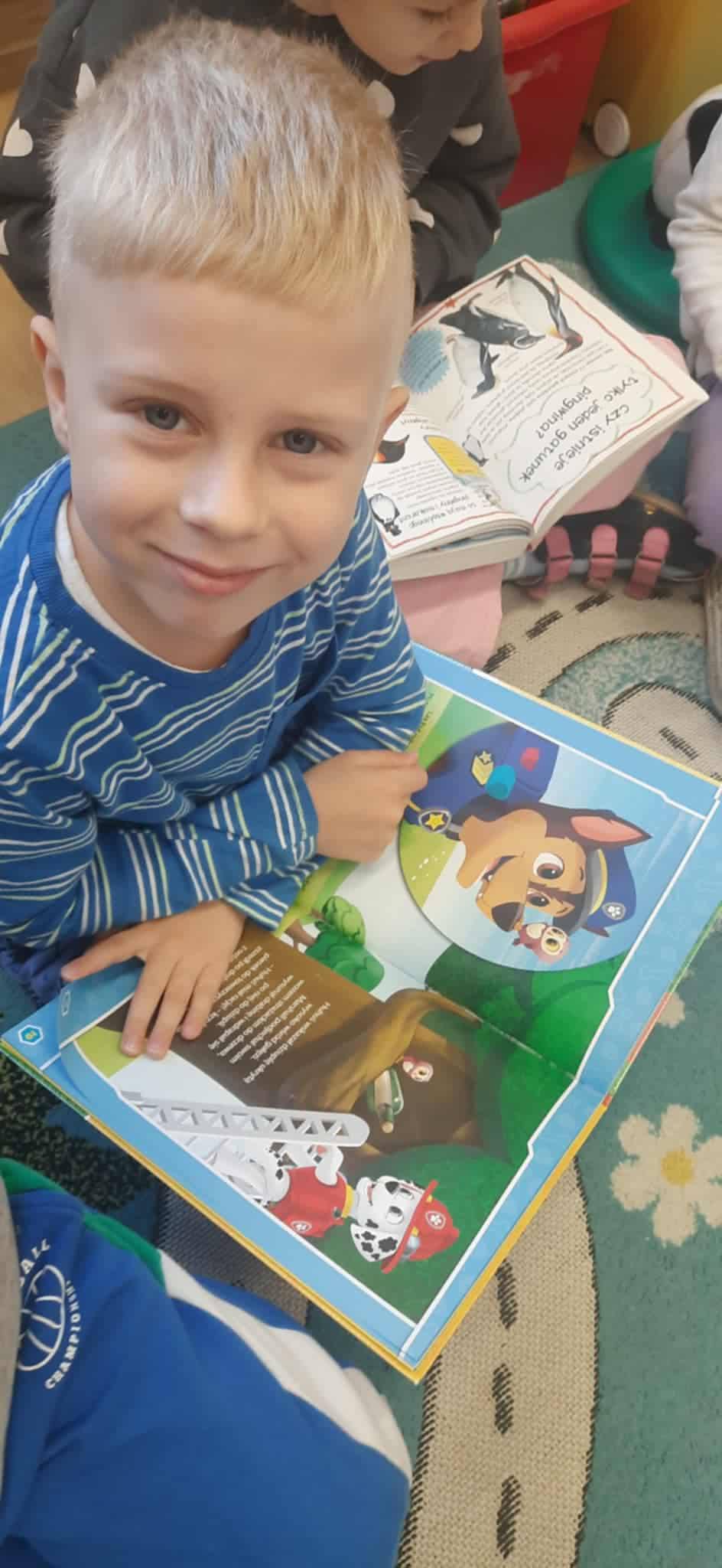 Chłopiec czytający książkę, biorący udział w akcji "Przerwa na czytanie"