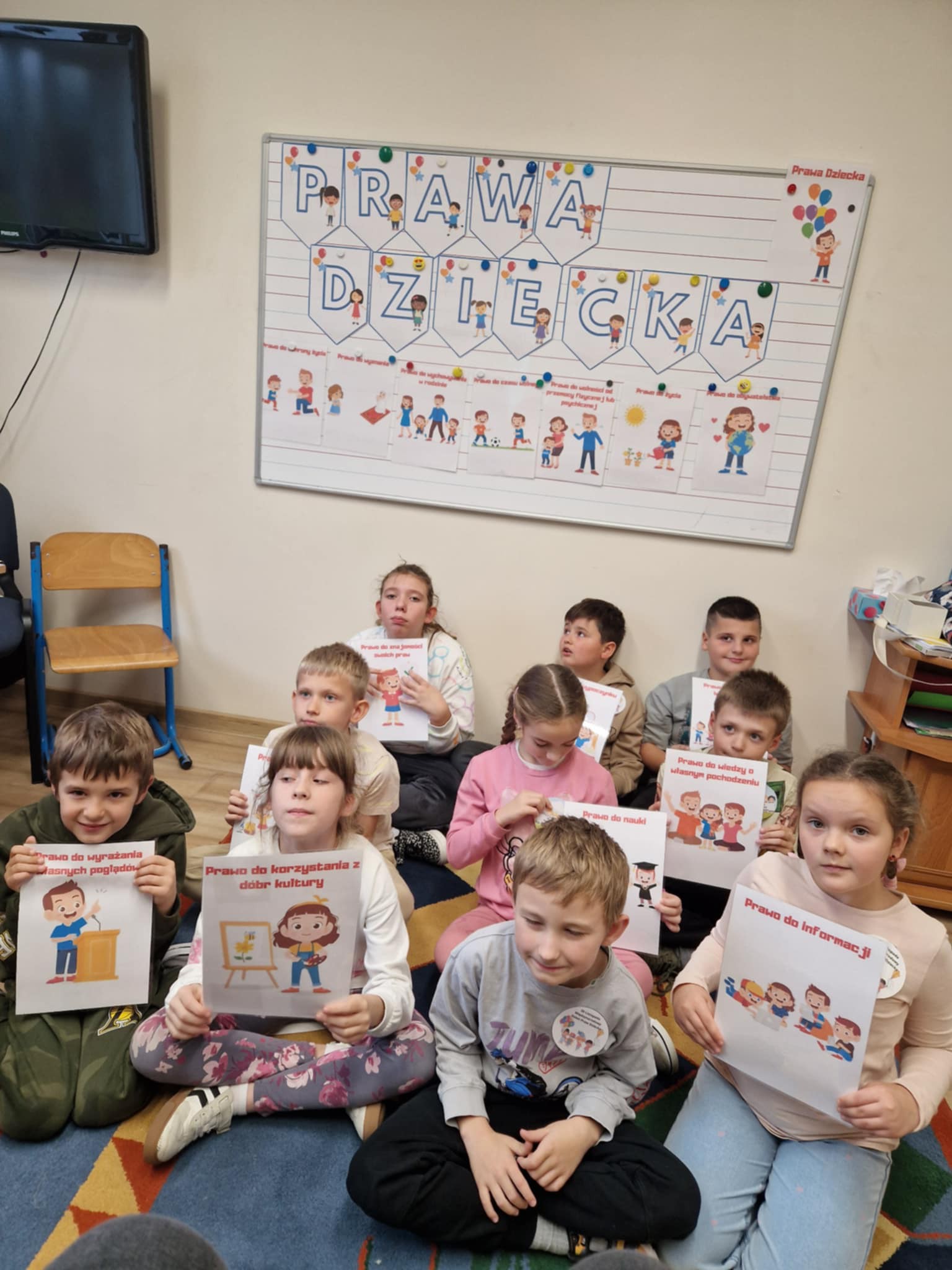 Dzieci z II klasy na tle tablicy na której pisze PRAWA DZIECKA