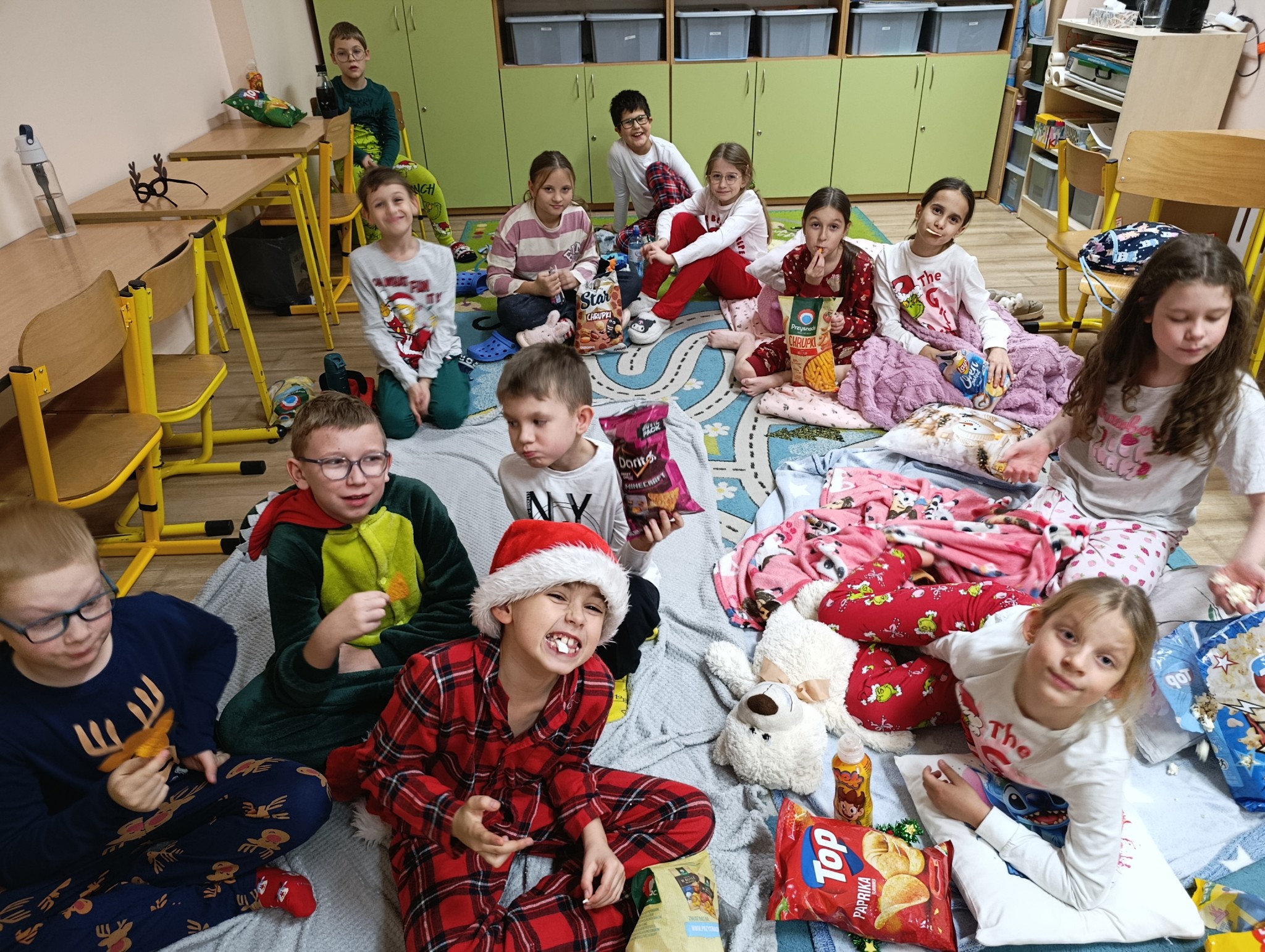 Uczniowie ubrani w kolorowe piżamy, oglądający seans filmowy